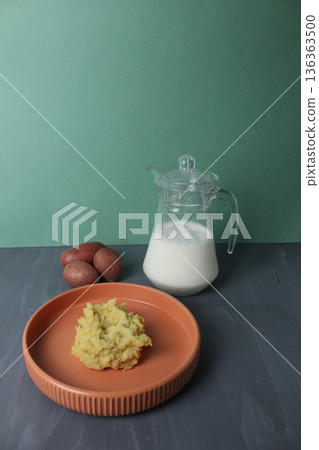 Mashed potatoes side dish of potatoes with milk in a jug on a gray background with space for text. Vegetarian Concept Vertical Photo Mashed potatoes side dish of potatoes with milk in a jug on a gray background with space for text. Vegetarian Concept Vertical Photo 136363500