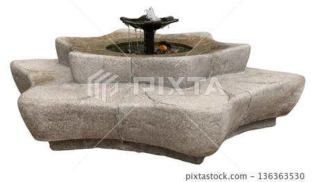 Water flows out from the center of a round stone fountain. The fountain has a unique design with a wide base and is placed outdoors. It is bright with sunlight shining down Water flows out from the center of a round stone fountain. The fountain has a unique design with a wide base and is placed outdoors. It is bright with sunlight shining down 136363530