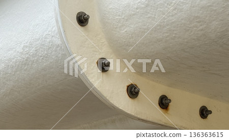 Industrial metal pipe with bolts showing rust, displaying texture and detail as a background Industrial metal pipe with bolts showing rust, displaying texture and detail as a background 136363615