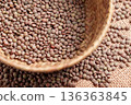 Dry brown lentils in wicker container on natural jute cloth. Plant based protein source. Uncooked diet ingredient 136363845