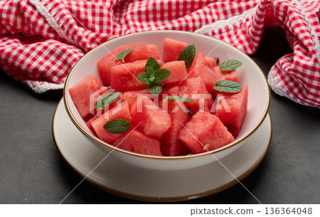 Plate full of diced watermelon garnished with fresh mint. Top view 136364048