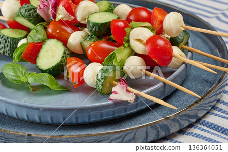 Italian appetizer with cherry tomatoes, cucumbers and mozzarella in a plate 136364051