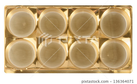Golden plastic candy tray, eight round cells, isolated background 136364071