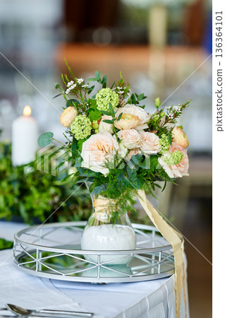 Wedding banquet table decorated with candles, flowers in elegant restaurant interior. White flower decor for wedding. Concept of celebration, romance, reception, event decoration. Wedding banquet table decorated with candles, flowers in elegant restaurant interior. White flower decor for wedding. Concept of celebration, romance, reception, event decoration. 136364101