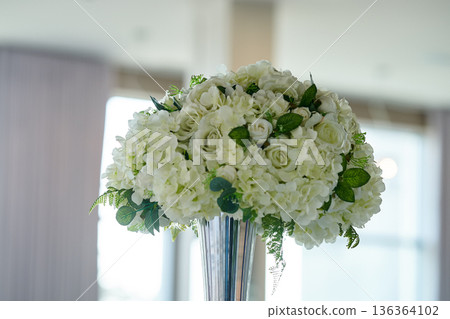 Wedding banquet table decorated with candles, flowers in elegant restaurant interior. White flower decor for wedding. Concept of celebration, romance, reception, event decoration. Wedding banquet table decorated with candles, flowers in elegant restaurant interior. White flower decor for wedding. Concept of celebration, romance, reception, event decoration. 136364102