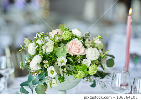 Wedding banquet table decorated with candles, flowers in elegant restaurant interior. White flower decor for wedding. Concept of celebration, romance, reception, event decoration. Wedding banquet table decorated with candles, flowers in elegant restaurant interior. White flower decor for wedding. Concept of celebration, romance, reception, event decoration. 136364103