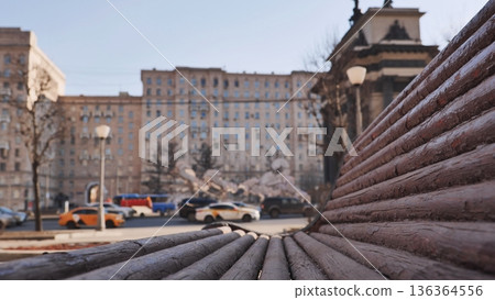 Wooden bench in Moscow park with street traffic and the Triumphal Arch of Moscow Wooden bench in Moscow park with street traffic and the Triumphal Arch of Moscow 136364556