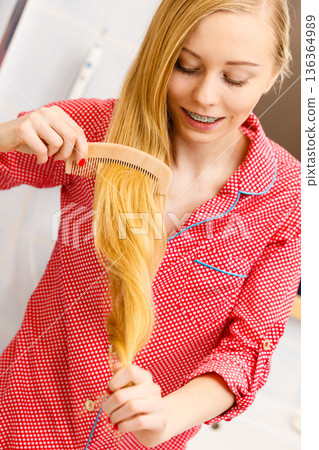 Woman combing her long hair in bathroom 136364989
