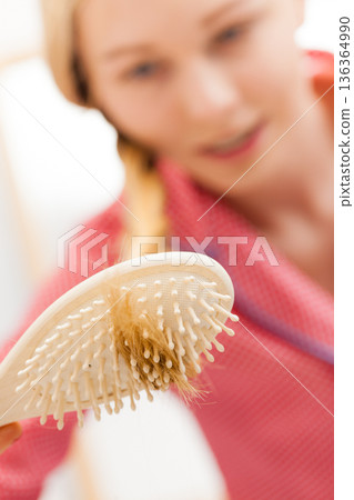 Woman brushing her long hair in bathroom Woman brushing her long hair in bathroom 136364990