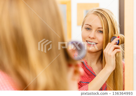Woman curling her hair using rollers Woman curling her hair using rollers 136364993