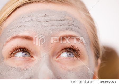 Closeup of woman having grey mud mask on face Closeup of woman having grey mud mask on face 136365005