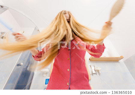Woman with long windblown blonde hair 136365010