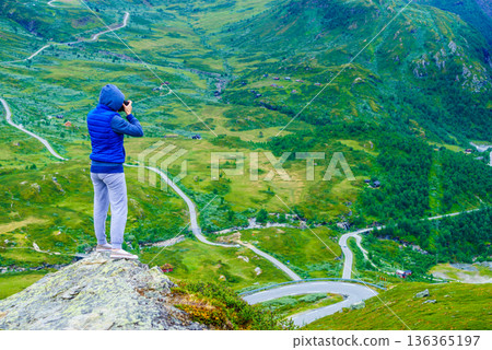 Tourist with camera and in Norway mountains Tourist with camera and in Norway mountains 136365197
