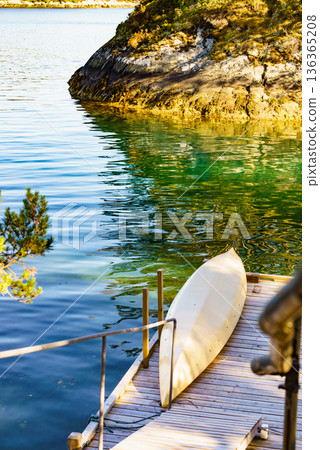 Old wooden pier with boat on lake 136365208