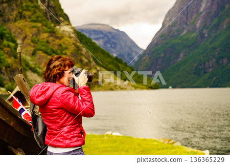 Tourist with camera near old viking boat, Norway Tourist with camera near old viking boat, Norway 136365229