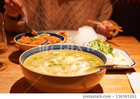 越南國民麵食:特寫鏡頭展現了米粉河粉和一位正在享用越南美食的亞洲女性。 越南國民麵食:特寫鏡頭展現了米粉河粉和一位正在享用越南美食的亞洲女性。 136365261