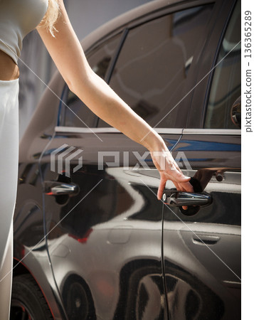 Fashionable woman opening car 136365289