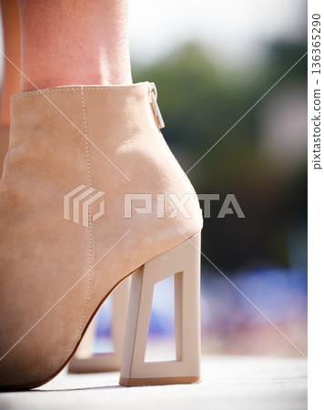 Woman wearing beige high heels boots Woman wearing beige high heels boots 136365290