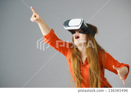 Girl wearing virtual reality goggles. 136365496