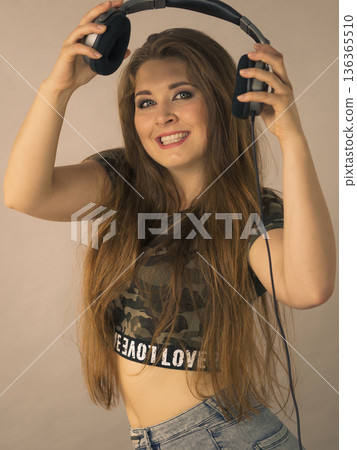 Teen women holding headphones 136365510