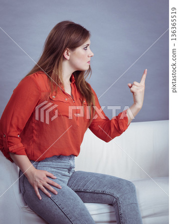 Angry woman sitting on sofa Angry woman sitting on sofa 136365519