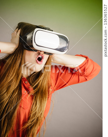 Girl wearing virtual reality goggles. 136365527