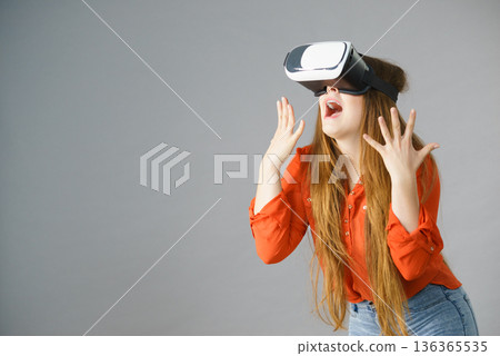 Girl wearing virtual reality goggles. 136365535
