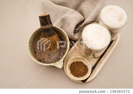 Preparing hojicha latte with tea powder and bamboo whisk Preparing hojicha latte with tea powder and bamboo whisk 136365572