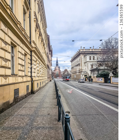 A classic European city street scene from Brno, Czech Republic. The view along Jostova street features historic buildings and the iconic Red Church spire.. High quality photo A classic European city street scene from Brno, Czech Republic. The view along Jostova street features historic buildings and the iconic Red Church spire.. High quality photo 136365599