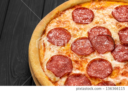 Pepperoni pizza on wooden board over dark rustic table, top view 136366115