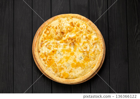 Quattro formaggi cheese pizza on wooden board, dark rustic background 136366122
