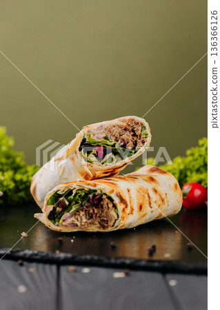 Grilled tuna tortilla wraps with greens, sauce and tomatoes on slate Grilled tuna tortilla wraps with greens, sauce and tomatoes on slate 136366126