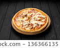 Cheesy chicken and mushroom pizza on wooden board, dark background 136366135