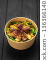 Warm liver salad with caramelized pear, mixed greens and crispy onions in kraft bowl 136366140