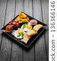 Breakfast plate with fried eggs, sausage, potato wedges and bread, top view 136366146