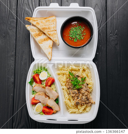 Takeaway meal box with tomato soup, toasted bread, creamy pasta and chicken salad Takeaway meal box with tomato soup, toasted bread, creamy pasta and chicken salad 136366147
