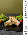 Grilled chicken tortilla wraps with greens and sauce on black slate 136366148