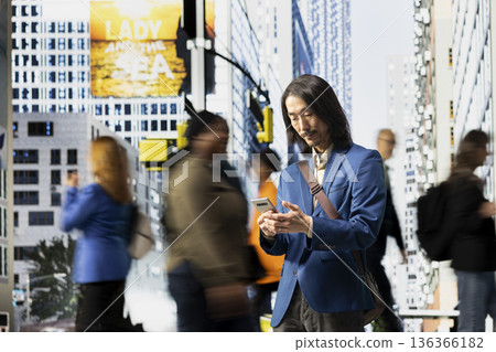 Asian modern professional browsing his smartphone apps in the street, walking along diverse pedestrian group downtown. Multicultural crowd of people and realistic urban environment. Asian modern professional browsing his smartphone apps in the street, walking along diverse pedestrian group downtown. Multicultural crowd of people and realistic urban environment. 136366182