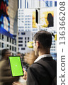 Vertical green screen on tablet with indian adult near busy crosswalk with urban people highlighting different lifestyles, multicultural crowd and everyday street activity in a metropolitan area. 136366208