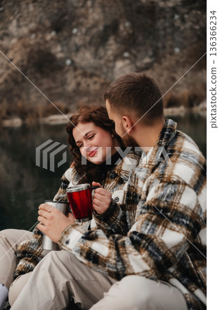 Couple enjoys warm drinks by the water while celebrating their relationship on Valentines Day Couple enjoys warm drinks by the water while celebrating their relationship on Valentines Day 136366234