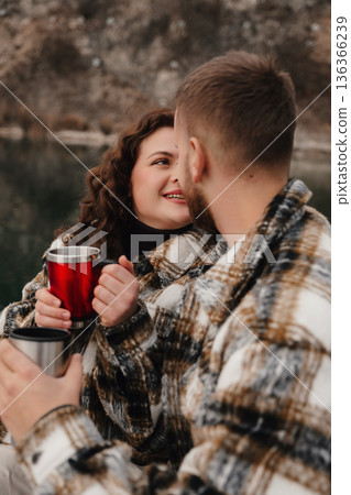 Couple enjoys warm drinks together by the water on Valentines Day 136366239