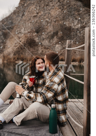 Couple sharing a moment by the water on Valentines Day while wearing matching outfits Couple sharing a moment by the water on Valentines Day while wearing matching outfits 136366242