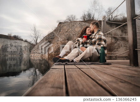 Couple shares a moment by the water on Valentines Day near a quiet spot surrounded by nature 136366245