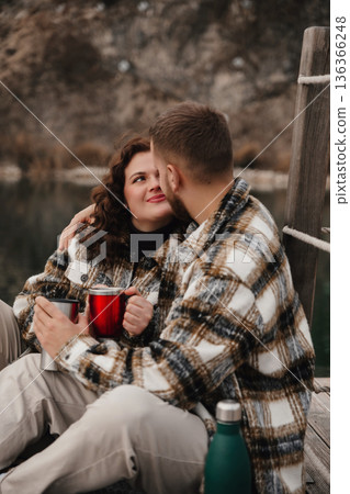 Couple enjoys warm drinks by the water on Valentines Day while expressing love and affection for each other 136366248