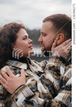 Couple shares a romantic moment during a winter stroll on Valentines Day by the lake Couple shares a romantic moment during a winter stroll on Valentines Day by the lake 136366271