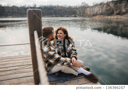 Couple enjoys a moment by the water on a wooden dock during Valentines Day 136366287