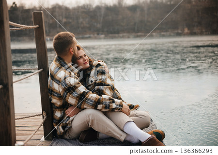 Couple sits by the water enjoying each others company on Valentines Day 136366293