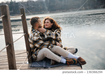 Couple sharing a moment on the dock by the lake on Valentines Day during a sunny afternoon in early spring 136366294