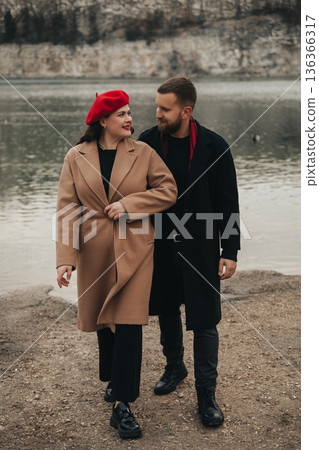 Couple walks hand in hand by the lake during Valentines Day celebrating their love and romance Couple walks hand in hand by the lake during Valentines Day celebrating their love and romance 136366317