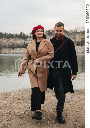 Couple walks by the lake on Valentines Day enjoying a moment of romance and connection in the chilly weather 136366320